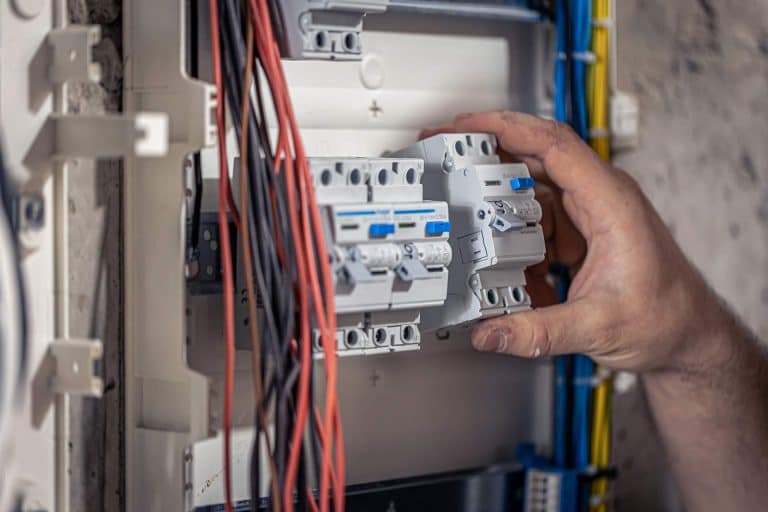 Elektryk przy rozdzielni w trakcie montażu - profesjonalne instalacje elektryczne Police.